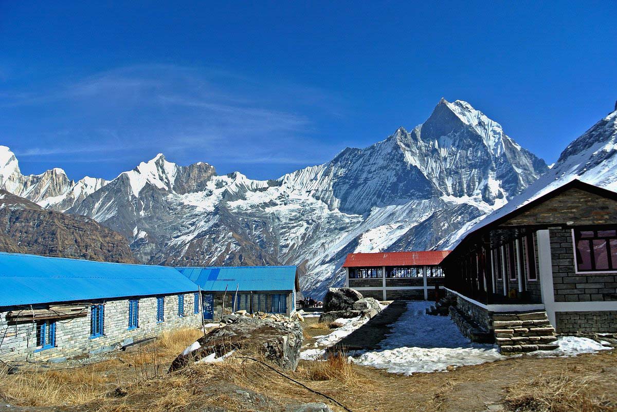 Mountain Guesthouse buildings in front of a mountain in Annapurna Base Camp trek 