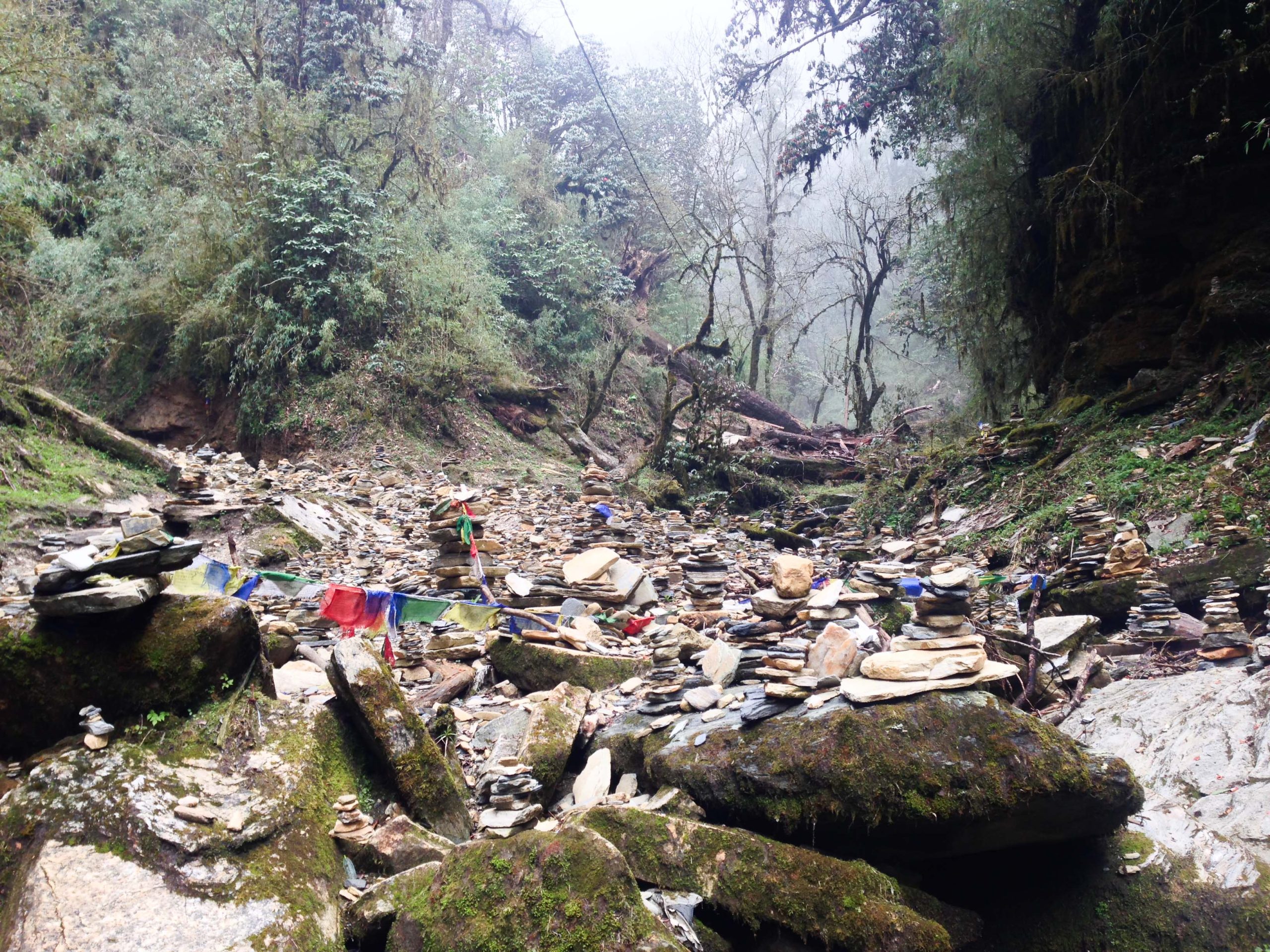 a rocky area with rocks and flags enroute of Annapurna base camp trek 
